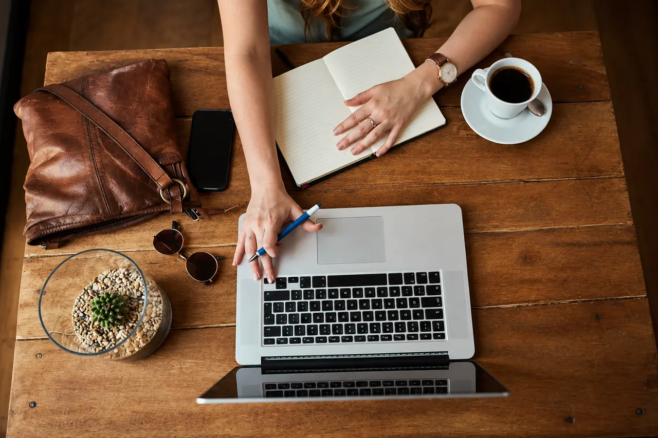 Carnet, ordinateur portable et café sur une table de travail